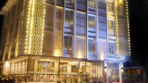 A hotel with a modern facade, illuminated vertical light patterns, and a visible sign reading 'CORDELAIR'. - Cordela Inn Bengkulu (Bengkulu)