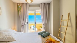 A hotel room with a bed, a breakfast tray with croissants and orange juice, a balcony with yellow railing, and a wooden ladder. - Calahonda Royale Seaview Suite, Mijas Costa, Spain (Mijas Costa)