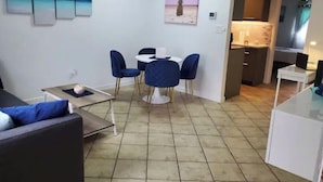 Ein kompakter Wohnbereich mit Essplatz, einer Küchenzeile und einem Sofa.