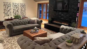 A modern living room with a fireplace, grey sofas, and a coffee table.