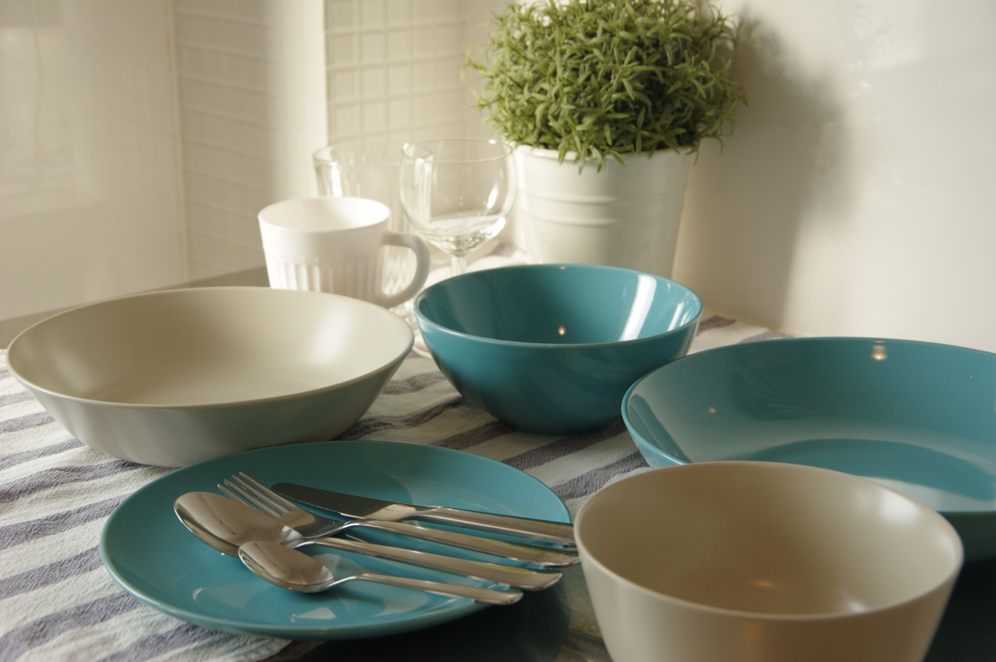 A dining table with various bowls, plates, and cutlery.