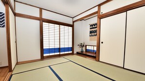 Une pièce de style japonais traditionnel, avec un sol recouvert de tatamis, des paravents shoji et une porte coulissante.