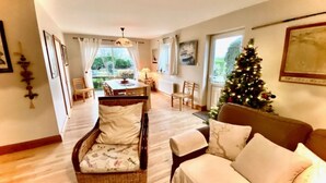 A cozy living room with a wicker chair, a sofa, and a Christmas tree. - Fough East, Cozy and close to town (Oughterard)