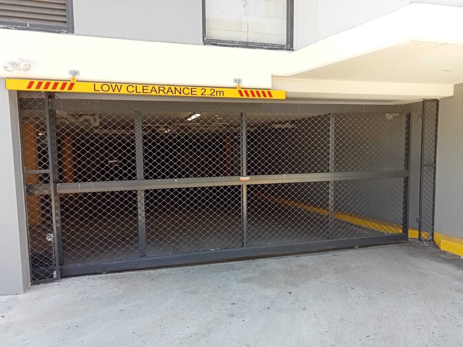 A gated parking area with a low clearance sign indicating 2.2 meters.