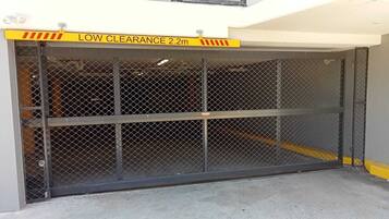 A gated parking area with a low clearance sign indicating 2.2 meters.