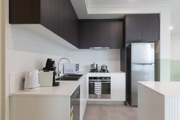 Apartamento premium, 2 quartos | Cozinha privada | Geladeira grande, micro-ondas, fogão, cooktop