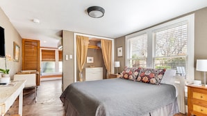 A bedroom with a large bed, a desk, and a wardrobe.