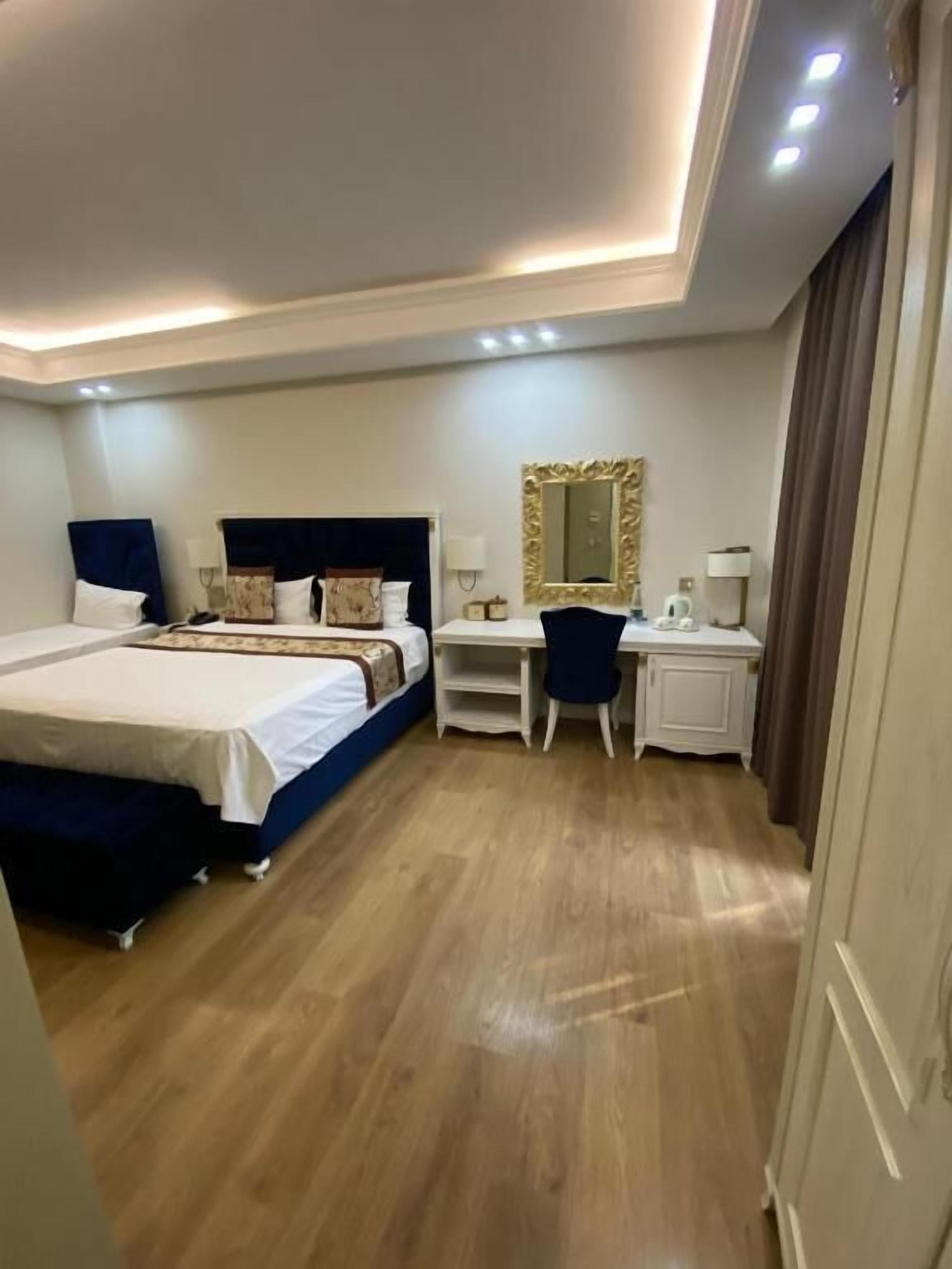 Una habitación de hotel con cama, escritorio y espejo.