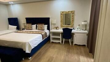 Una habitación de hotel con cama, escritorio y espejo.