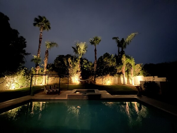 Relax by the pool surrounded by palm trees and a hammock.