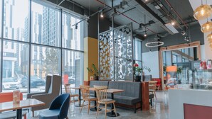 A modern cafe with large windows, wooden furniture, and a decorative wall panel. - YE'S APART ASTANA (Astana)