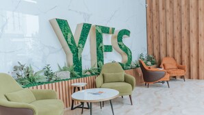 A modern lobby with a large 'YES' sign, green plants, and two armchairs. - YE'S APART ASTANA (Astana)