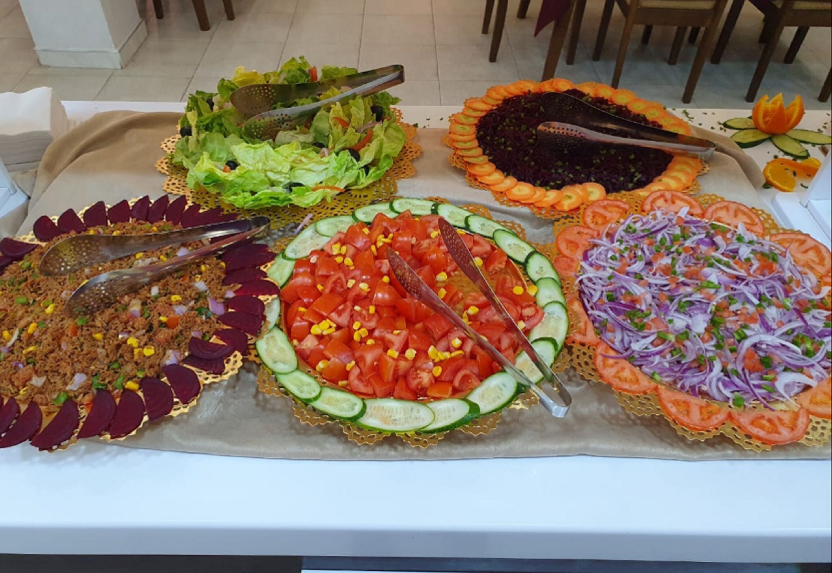 A table with various food items including salads and a fish dish.