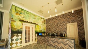 A kitchen with a herringbone-patterned wall, a wooden floor, and a bar area with a television.