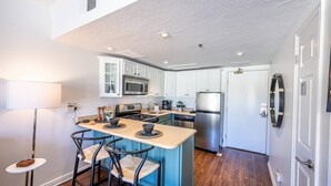A modern kitchen with white cabinets, stainless steel appliances, and a central island with bar stools. - Labor Day Sale - Limited Time Offer, Save up to 30% (Park City)