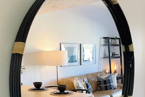 A living room with a sofa, a table with a bowl, a lamp, and framed pictures on the wall. - Studio 580 Main (Park City)