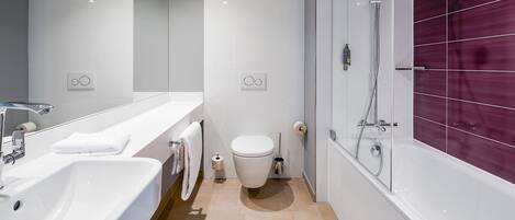 Un baño moderno con lavabo, inodoro y ducha.