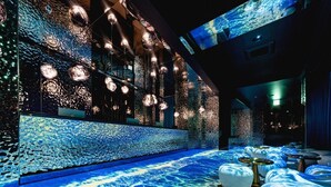 A modern interior with a reflective wall, hanging spherical lights, and a patterned floor. - Best Louis Hamilton Hotel Ocean Terrace (Busan)