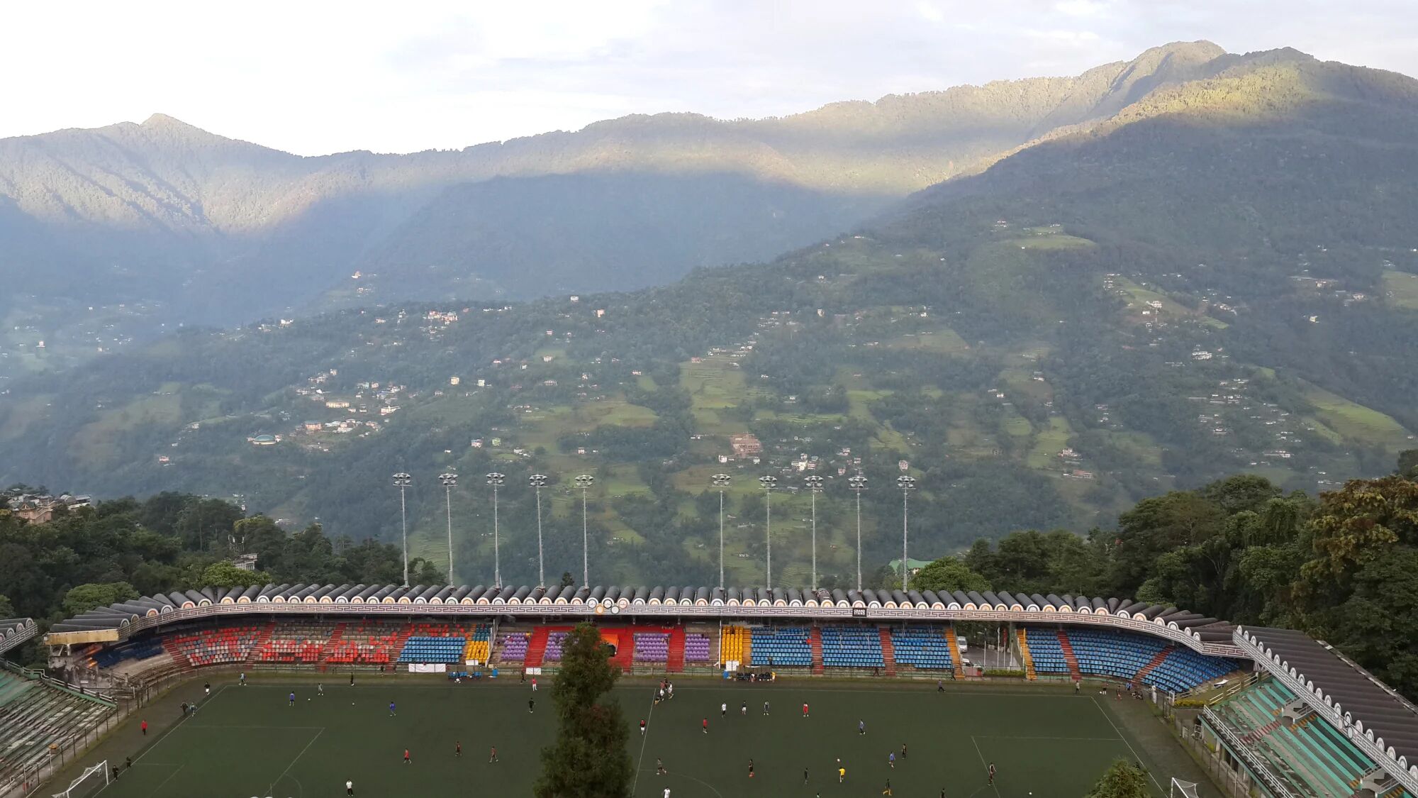 Ein Stadion mit einem Fußballplatz, umgeben von Bergen.