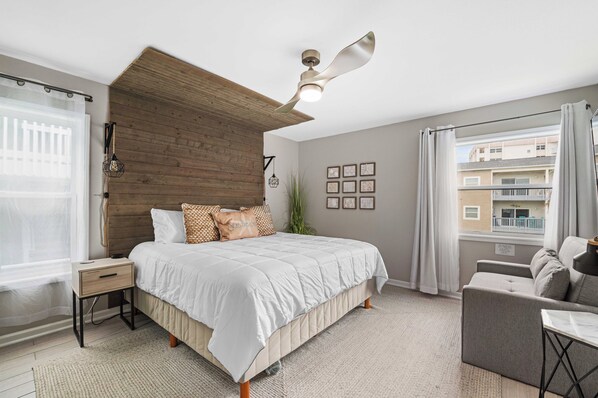 A bedroom with a bed, bedside table, and a ceiling fan.