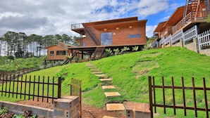 A modern multi-story building with a staircase leading up to a wooden deck.