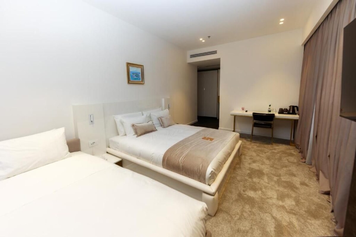 Een hotelkamer met twee bedden, een bureau en een kledingkast.