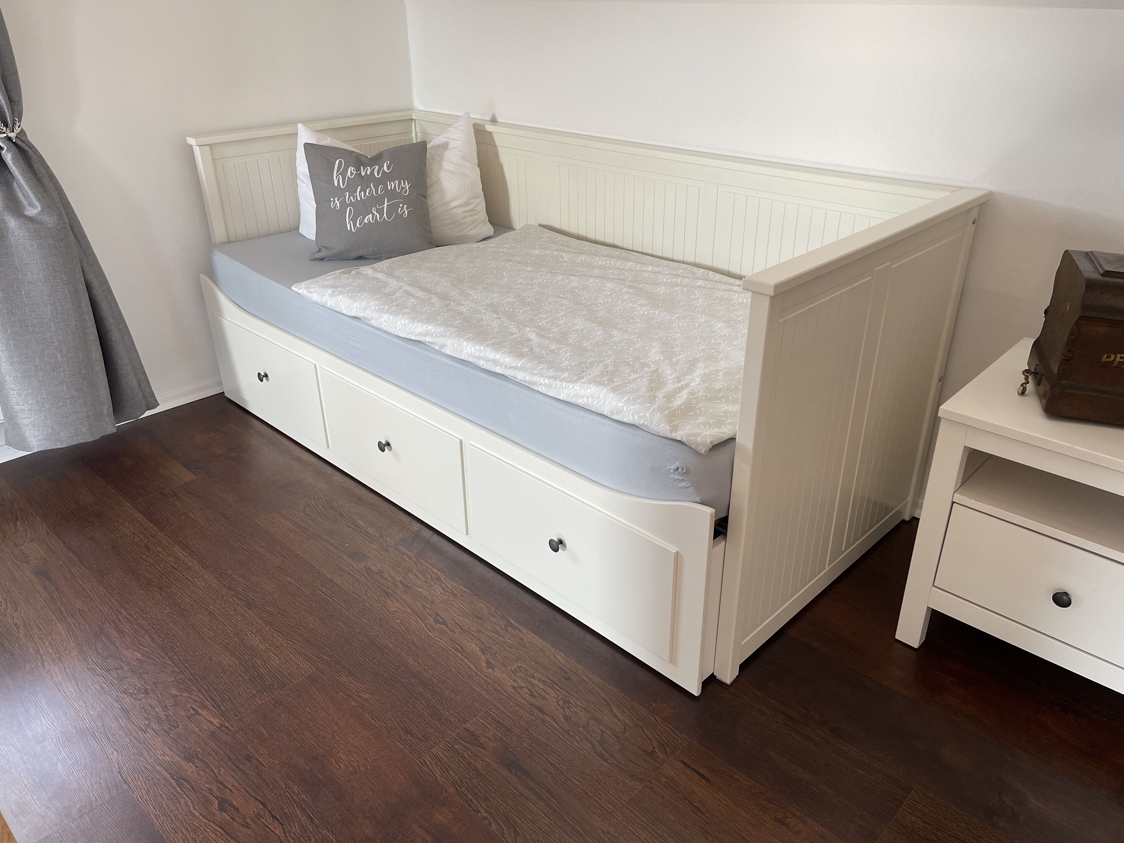 Un dormitorio con una cama, una mesita de noche y un aparador.