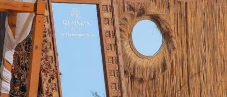 Una yurta tradicional con una abertura circular, estructura de madera con tallas intrincadas y un letrero que dice "RANISOS HOTEL Let The Adventure Begin!".
