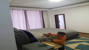 A bedroom with a bed, a desk, and a chair.