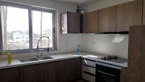 A modern kitchen with wooden cabinets, a stainless steel sink, and a built-in oven.