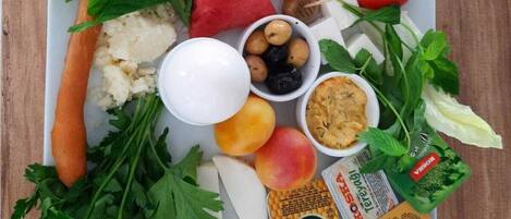 Un plato de comida con sandía, pepino, tomate, queso y aceitunas.