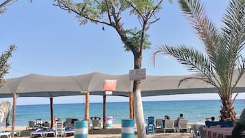 Privéstrand vlakbij, ligstoelen aan het strand, parasols, een strandbar