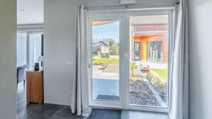 Un interior moderno con un puerta corrediza de vidrio que da a un jardín.