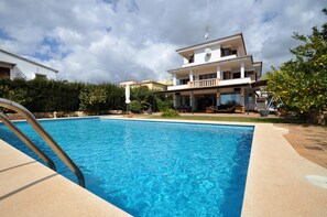 Une grande piscine, avec une maison moderne en arrière-plan.