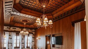 A spacious bedroom with a large bed, wooden ceiling, and a television mounted on the wall. - Kerculla Resort  (Gjirokastër)