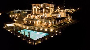 A large, illuminated hotel with a swimming pool, multiple dining areas, and a prominent tower structure. - Kerculla Resort  (Gjirokastër)