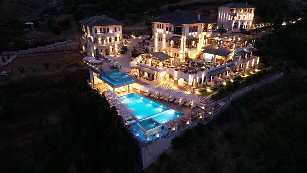 A large, multi-story hotel with a swimming pool and outdoor seating areas. - Kerculla Resort  (Gjirokastër)