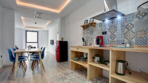 A modern kitchen with a wooden table and chairs, a built-in oven, and a patterned backsplash. - Modern two bedroom apartment (Ronda)