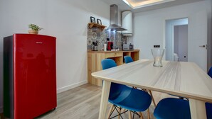 A modern kitchen with a red refrigerator, a wooden cabinet, and a tiled backsplash. - Modern two bedroom apartment (Ronda)