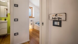 Ein Hotelzimmer mit einem Bett, einem Nachttisch, einem Fenster und einem Schild mit der Aufschrift 'Suite Jin'.