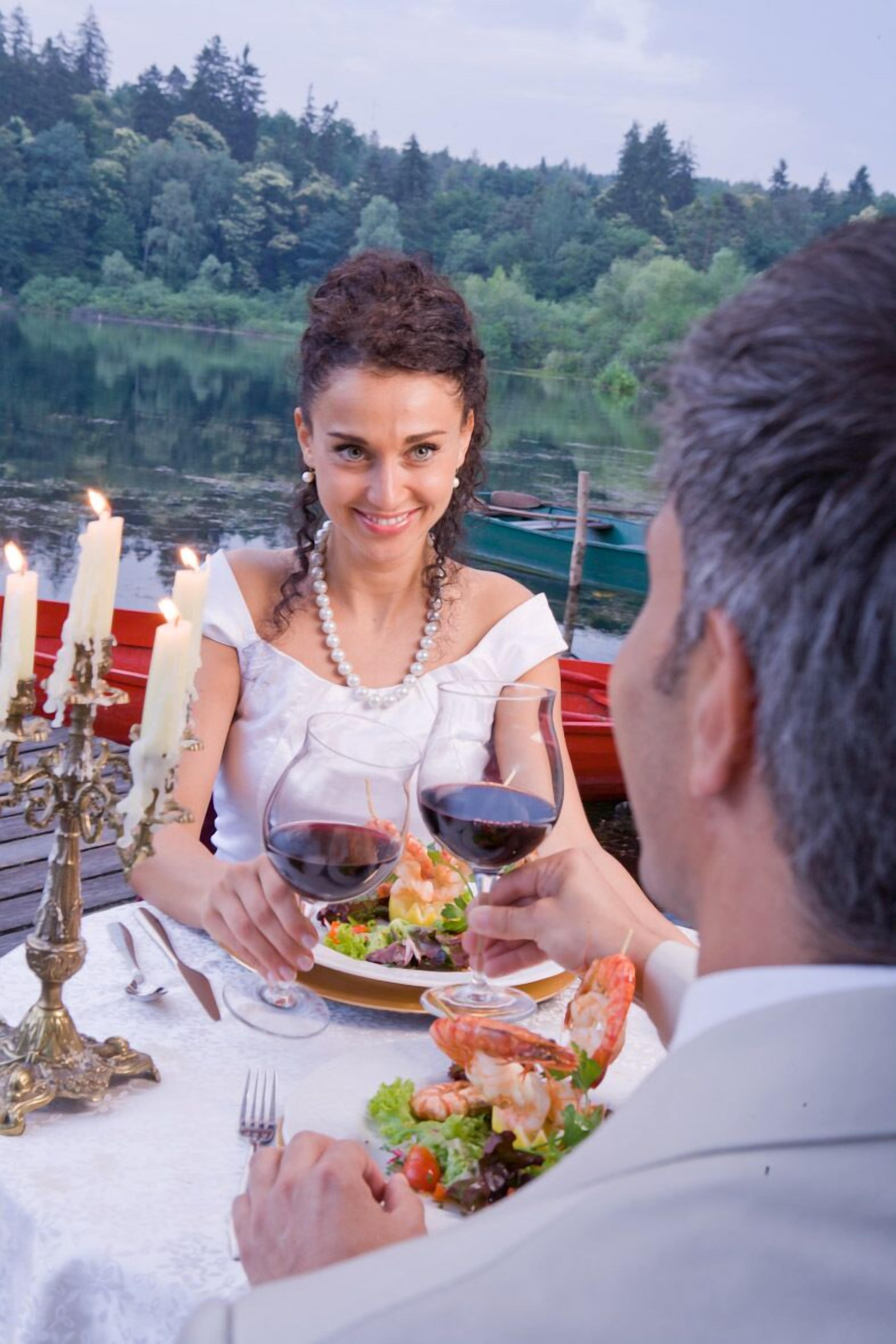 Une table à manger avec un chandelier, des assiettes remplies de nourriture et des verres à vin.
