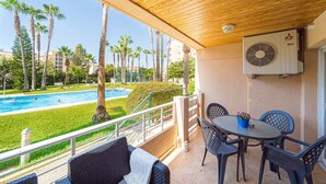 Un espace extérieur abrité comprenant une piscine, des chaises et une table.