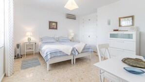 Een slaapkamer met een bed, nachtkastjes, een bureau en een stoel.