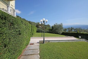 A landscaped area with a lamp post, steps, and a building in the background.