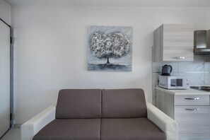 A modern kitchen with a microwave, kettle, and cabinets.