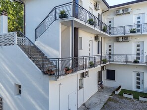 Ein mehrstöckiges Gebäude mit Balkonen, Klimaanlagen und einem Fahrrad.