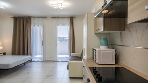 A modern kitchen with a built-in microwave, a stove, and a water dispenser. - Studio Apartment "Planet Suite 303 Bibione" with Wi-Fi (San Michele al Tagliamento)