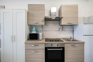 A kitchen with a microwave, oven, sink, and cabinets.
