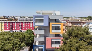 A multi-story building with balconies, a flat roof, and a clear sky. - Studio Apartment "Planet Suite 303 Bibione" with Wi-Fi (San Michele al Tagliamento)