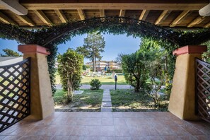 Un patio couvert offrant une vue sur un bâtiment en arrière-plan.